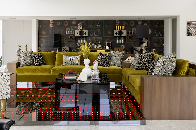 To resurrect the vibe of a filled-in conversation pit, an LED "dance floor" was constructed where the pit was formerly located, and framed by wood-clad furniture.